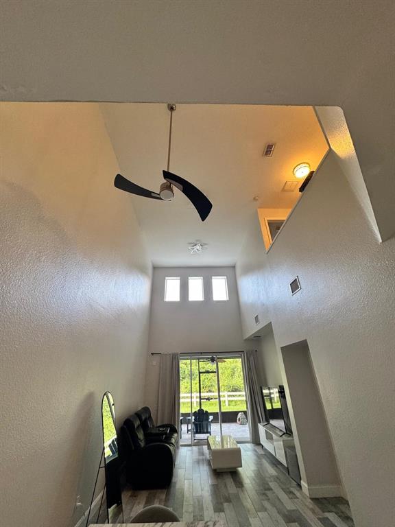 A living room with high ceilings, a ceiling fan, large windows, and sliding glass doors — 1609 CROYDON STREET, ORLANDO, FL