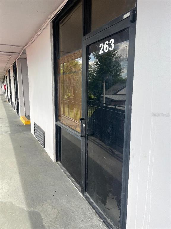 A glass-paneled commercial door marked with the number 263 sits along an outdoor walkway — 8421 S ORANGE BLOSSOM TRAIL UNIT 263, ORLANDO, FL