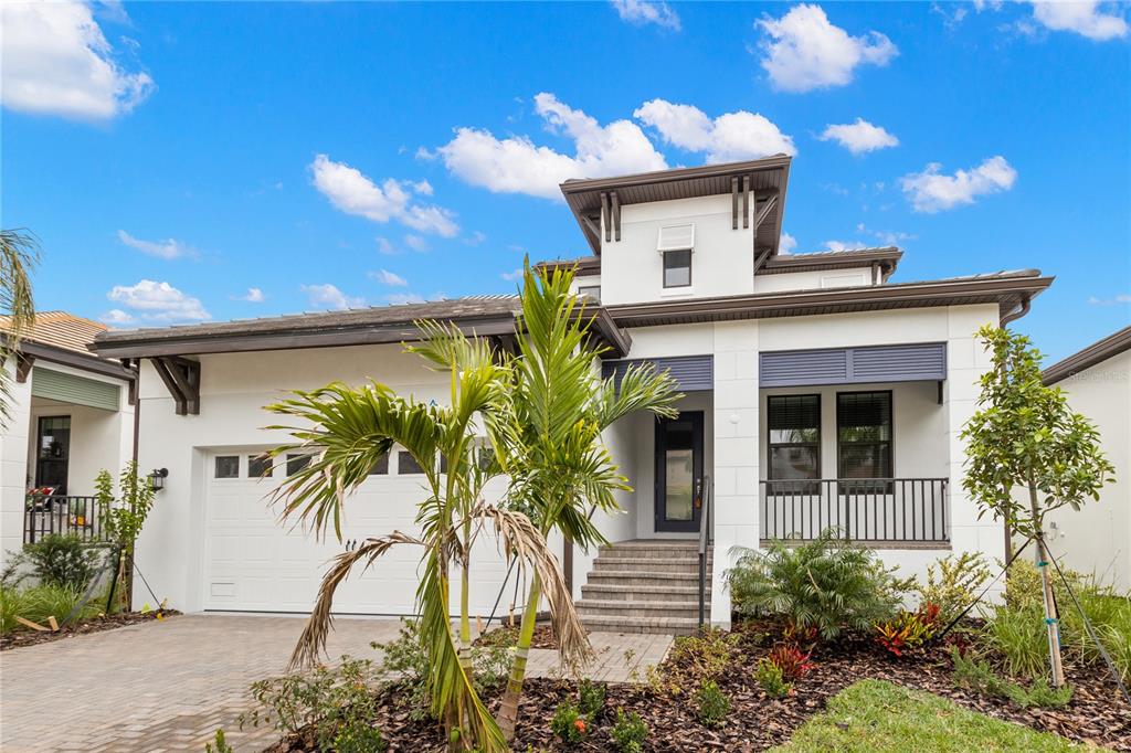 A modern two-story house with a white stucco facade, a garage, and a front porch — 1011 SEAGRAPE DRIVE, RUSKIN, FL