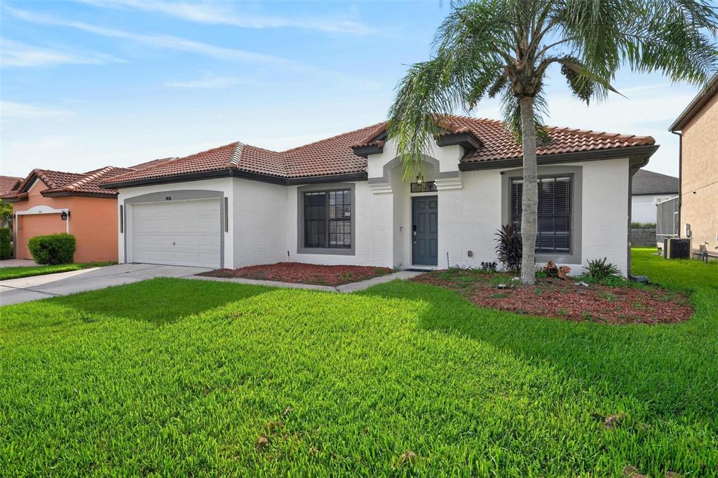 A single-story house with a white stucco exterior, a tile roof, and a two-car garage — 3016 CAMINO REAL DRIVE S, KISSIMMEE, FL