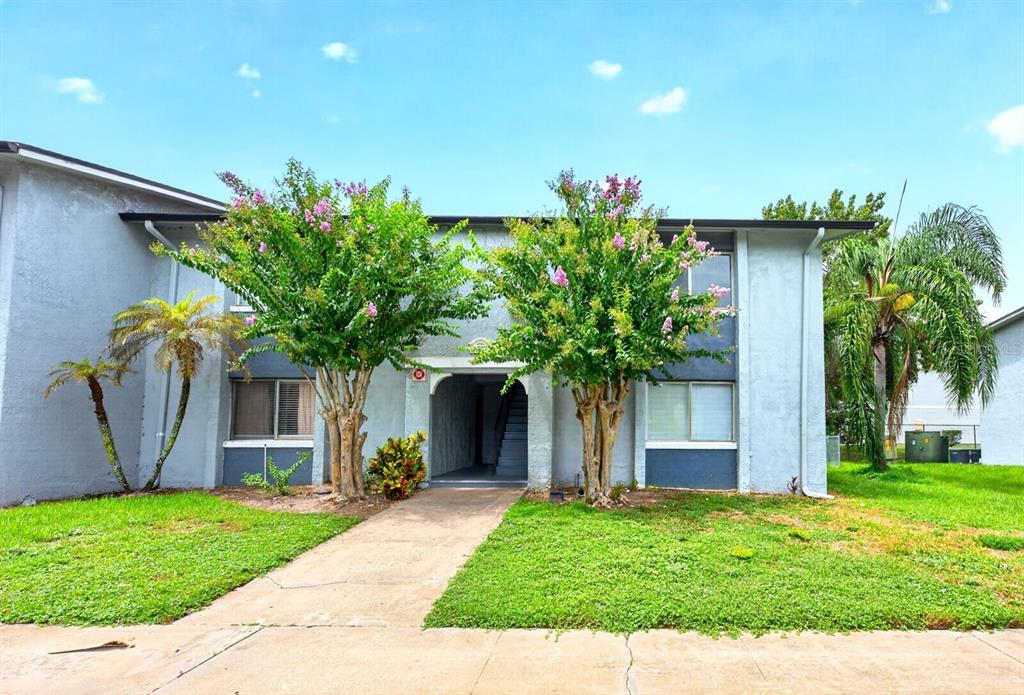 A gray apartment door with a lockbox and a Jordan logo sits beside a staircase — 4737 S TEXAS AVENUE UNIT 4737D, ORLANDO, FL