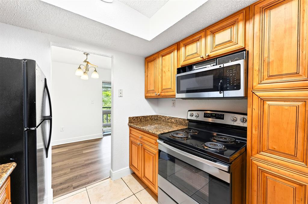 An empty living room with white walls, wood-look flooring, and a sliding glass balcony door — 4737 S TEXAS AVENUE UNIT 4737D, ORLANDO, FL