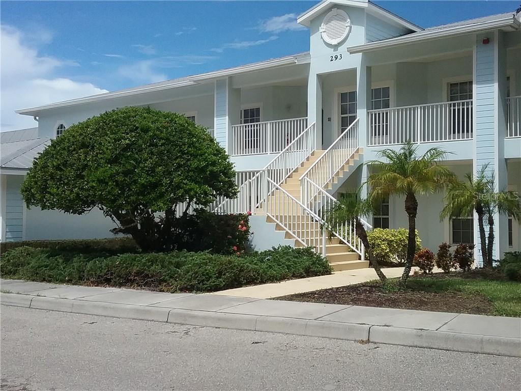 A two-story light blue building features a central staircase leading to an upper balcony — 293 HIDDEN BAY DRIVE UNIT 203, OSPREY, FL