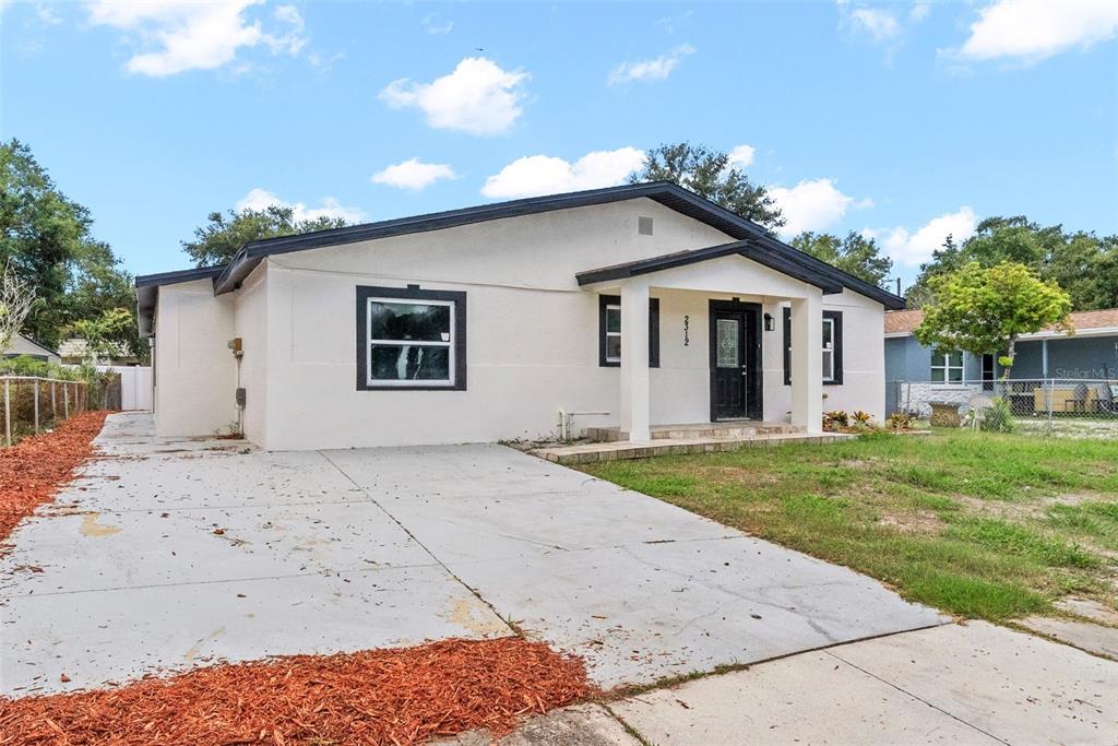 A white, single-story house with a concrete driveway and a covered front porch — 2312 22ND AVENUE SW, LARGO, FL