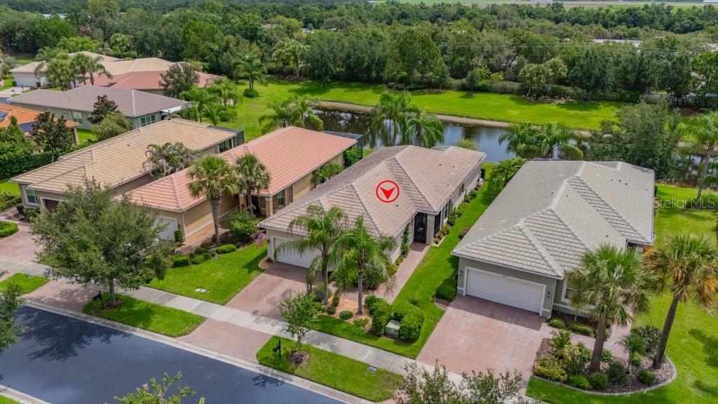 An aerial view of a suburban neighborhood featuring several houses with tiled roofs and lawns — 15824 AMBER FALLS DRIVE, WIMAUMA, FL