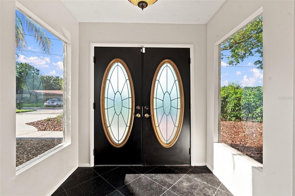 An entryway features black double doors with oval glass inserts and black tiled flooring — 2705 SILVER LAKE AVENUE, TAMPA, FL