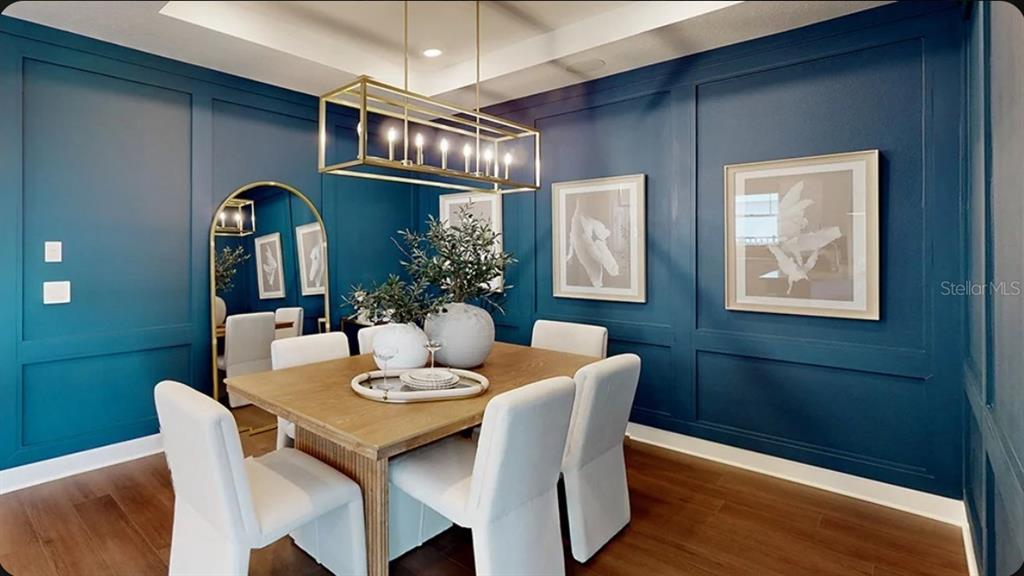 A dining room features blue paneled walls, a rectangular gold chandelier, and a wooden table — 11279 SILVER TRUMPET LOOP, WINTER GARDEN, FL