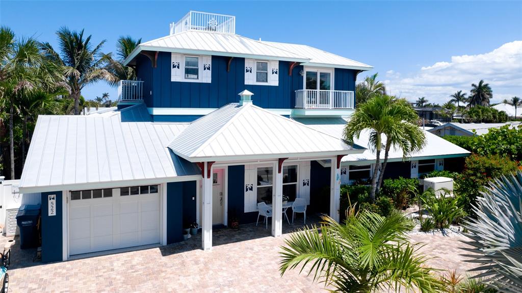 A two-story blue house with a white metal roof and a paved driveway — 522 68TH STREET, HOLMES BEACH, FL