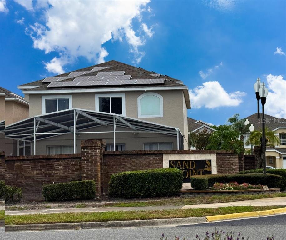 A two-story blue house with solar panels on the roof and a front yard — 1203 SANDESTIN WAY, ORLANDO, FL
