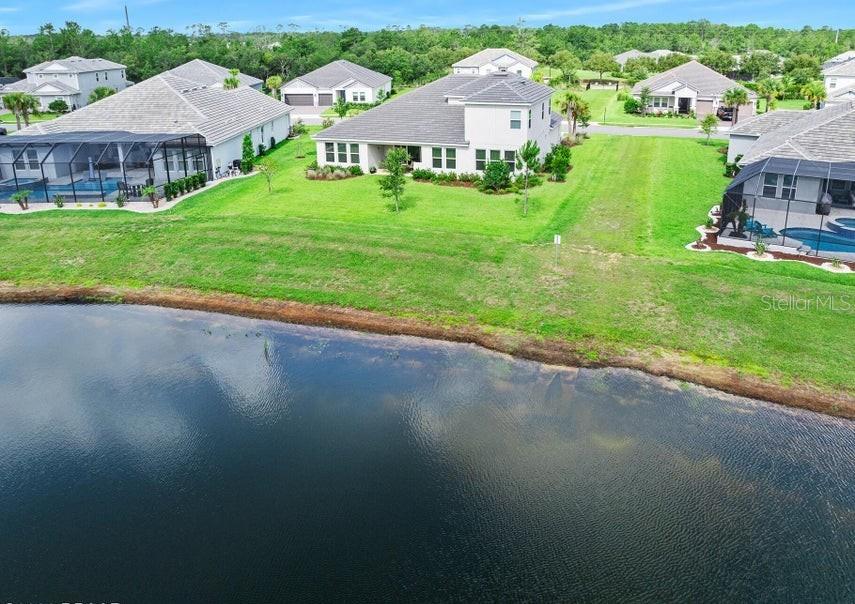 An aerial view of several suburban houses with swimming pools situated along a pond — 1369 ARKLOW CIRCLE, ORMOND BEACH, FL