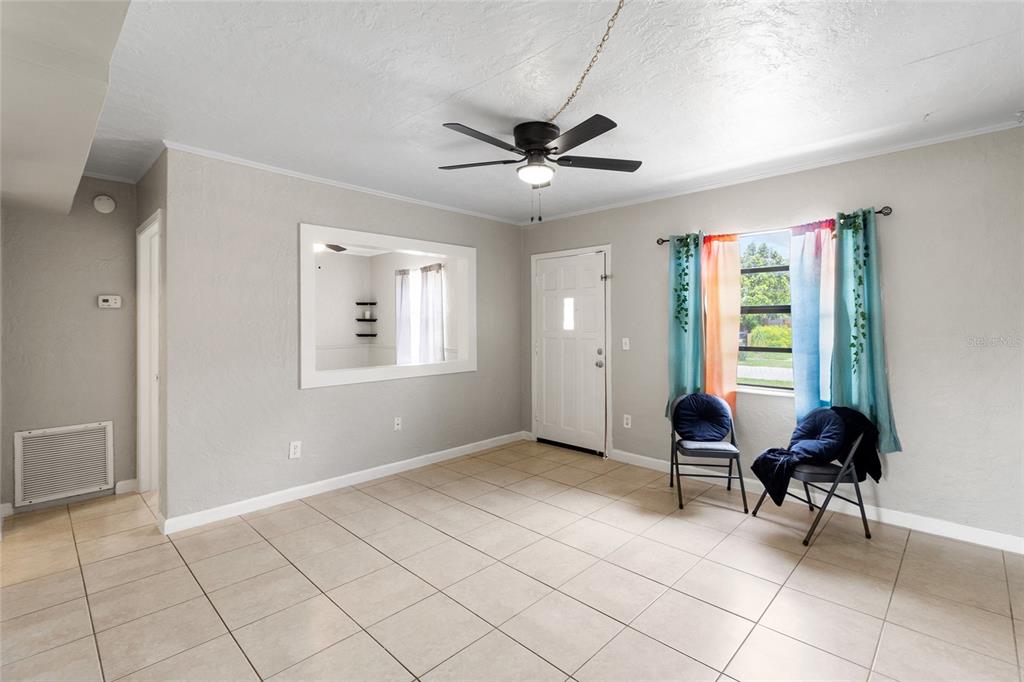 A living room with light tile flooring, a ceiling fan, and a window with curtains — 5410 14TH AVENUE S, GULFPORT, FL