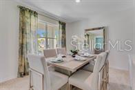 A dining room features a light wood table, upholstered chairs, and a large wall mirror — 5820 ARBORETUM STREET, ST CLOUD, FL