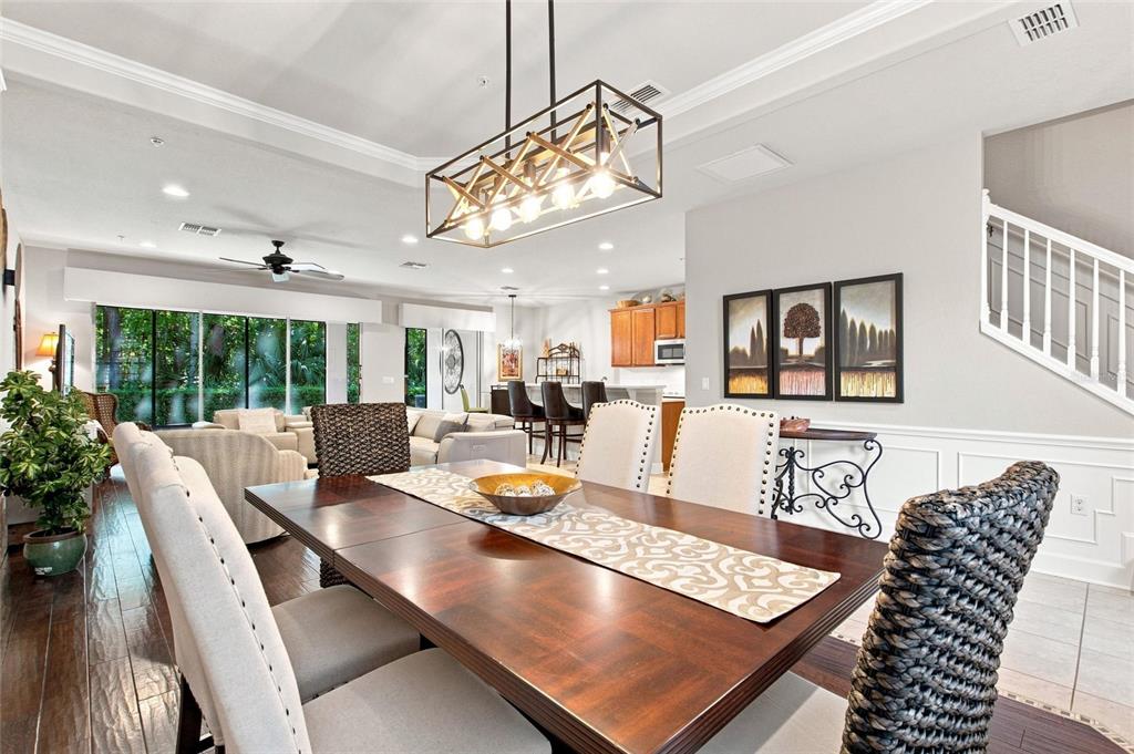 A dining room features a dark wood table, upholstered chairs, and a rectangular pendant light — 1411 LISBON CT, DAVENPORT, FL