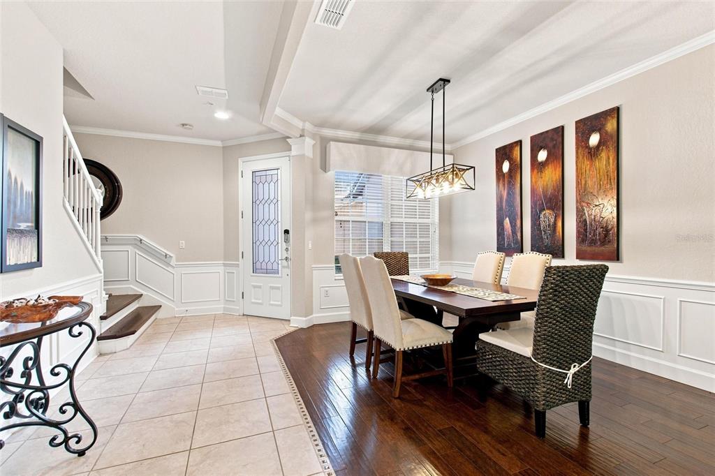 A dining room with a wooden table, chairs, a chandelier, and a staircase nearby — 1411 LISBON CT, DAVENPORT, FL