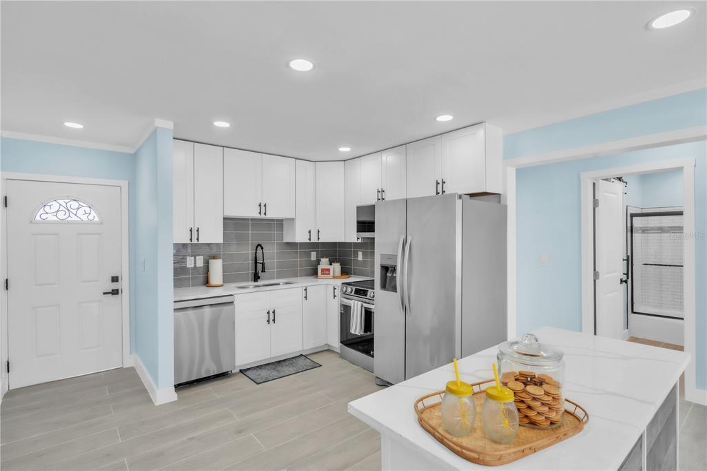 A single-story house with orange and yellow exterior walls features a white picket fence — 445 63RD STREET, HOLMES BEACH, FL