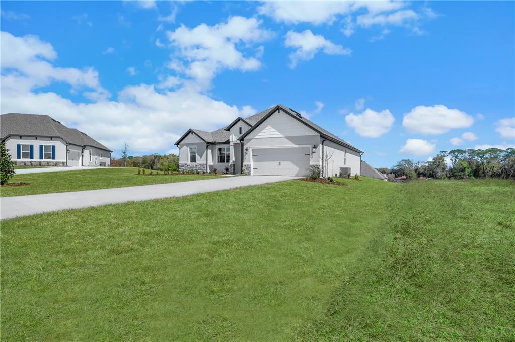 A single-story house with a white exterior, stone accents, and a two-car garage — 3849 SADDLE HILL TRAIL, FRUITLAND PARK, FL