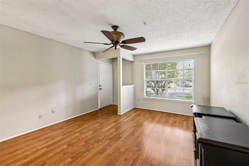 An empty room with wood-look flooring, a ceiling fan, and a window with white blinds — 124 RESERVE CIRCLE UNIT 100, OVIEDO, FL