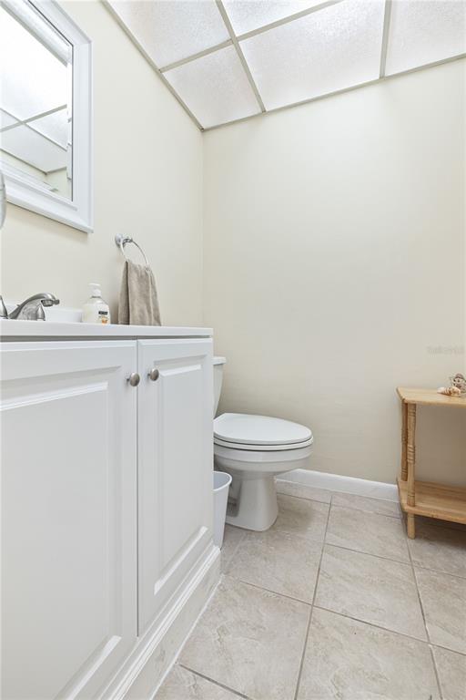 A bathroom features a white vanity, a toilet, and a small wooden side table — 19029 US HIGHWAY 19 N UNIT 3-1, CLEARWATER, FL