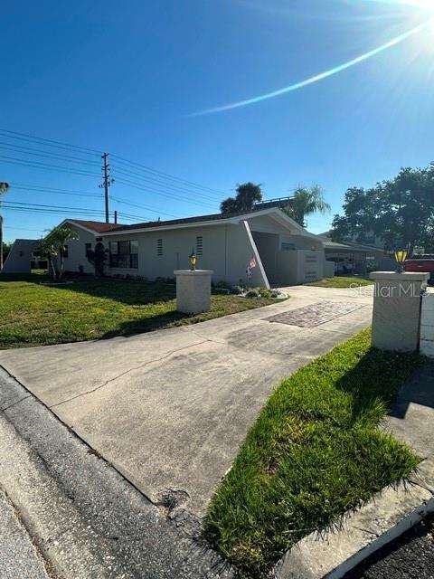 A single-story house with a concrete driveway and two decorative pillars in the front yard — 2301 W BAY DRIVE, LARGO, FL
