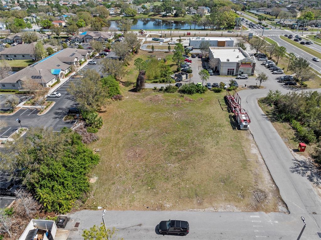 An aerial view shows a vacant rectangular lot situated between commercial buildings and parking lots — BIG BEND ROAD, RIVERVIEW, FL