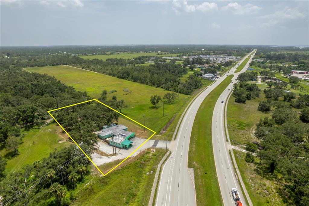 An aerial view shows a small building with a green roof situated on a wooded lot — 4214 DUNCAN ROAD, PUNTA GORDA, FL