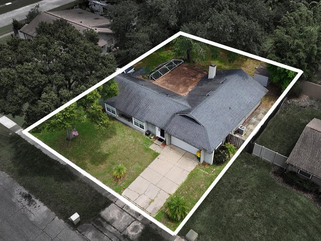An aerial view shows a single-story house with a shingled roof and a concrete driveway — 1792 PAM CIRCLE, BELLE ISLE, FL