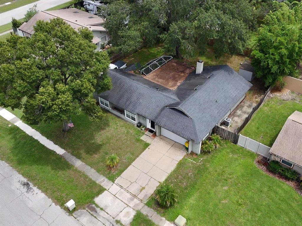 An aerial view shows a single-story house with a dark roof, garage, and backyard patio — 1792 PAM CIRCLE, BELLE ISLE, FL