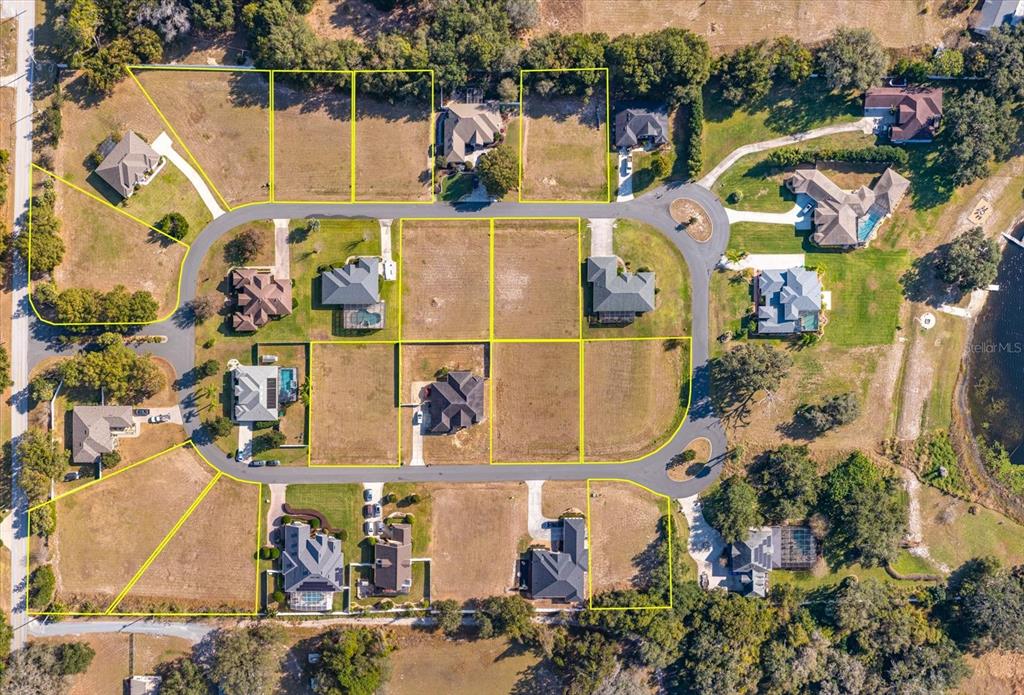 This aerial view shows a residential neighborhood with several houses and vacant lots — 1103 MYRTLE BREEZES COURT, FRUITLAND PARK, FL