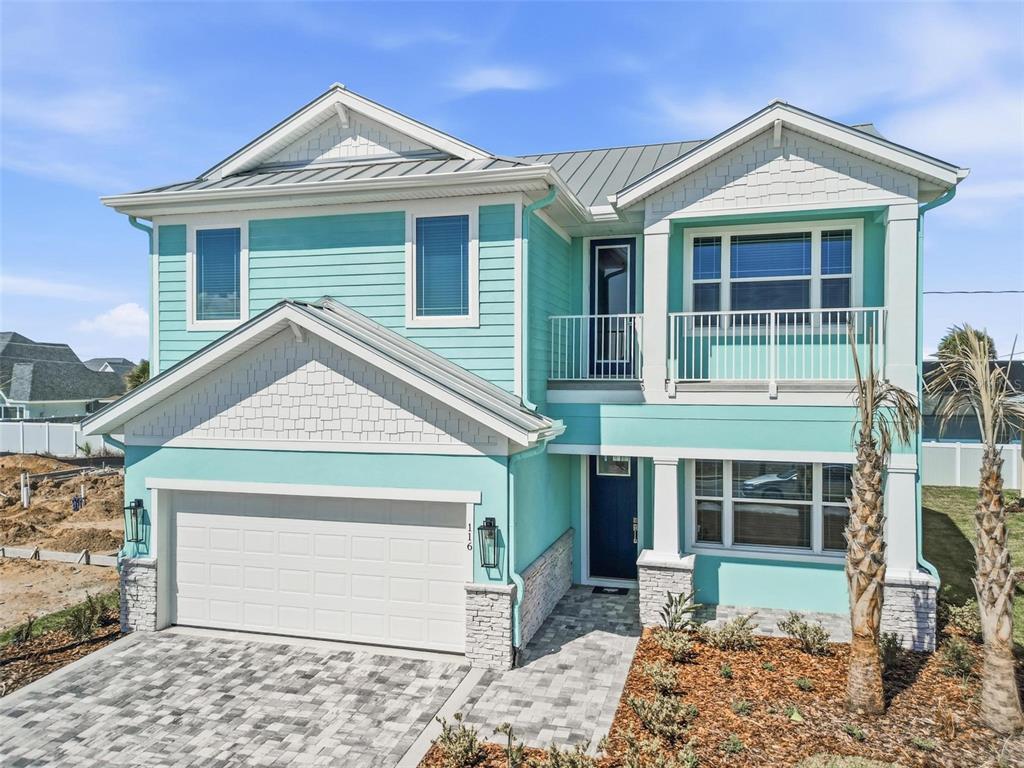 A two-story house with turquoise siding, a white garage, and a second-story balcony — 116 BEACHVIEW DRIVE, ORMOND BY THE SEA, FL