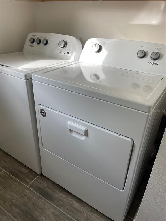 A white Whirlpool washer and dryer set sit on a tiled floor in a laundry room — 3032 CRISPIN CIRCLE, ST CLOUD, FL