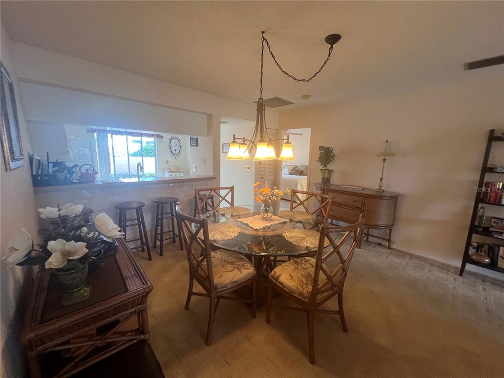 A covered entryway features a screen door, a wall-mounted light fixture, and a lattice privacy screen — 338 CERROMAR WAY N UNIT 4, VENICE, FL