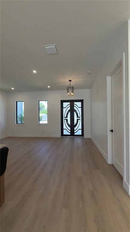 A modern kitchen features light wood cabinets, a central island with bar stools, and pendant lighting — 1103 ALPINE DRIVE, BRANDON, FL