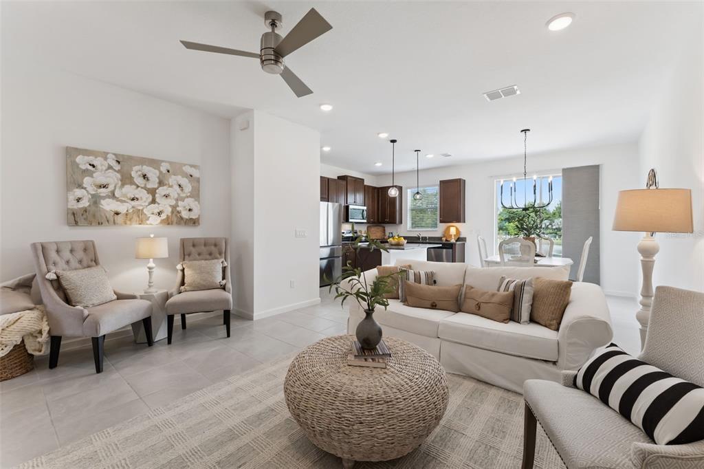 A paved patio overlooks a grassy lawn, a pond with a fountain, and dense trees — 1070 SPRING PALMS LOOP, ORLANDO, FL