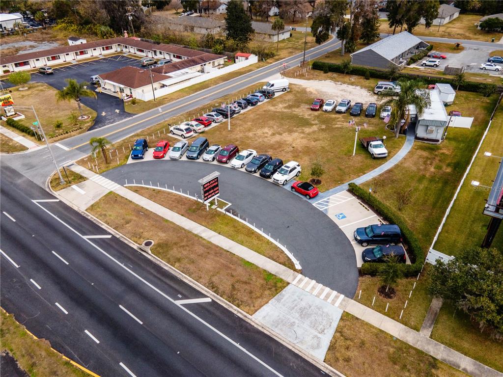 An aerial view shows a car dealership lot with parked vehicles next to a road — 3001 S PINE AVENUE, OCALA, FL