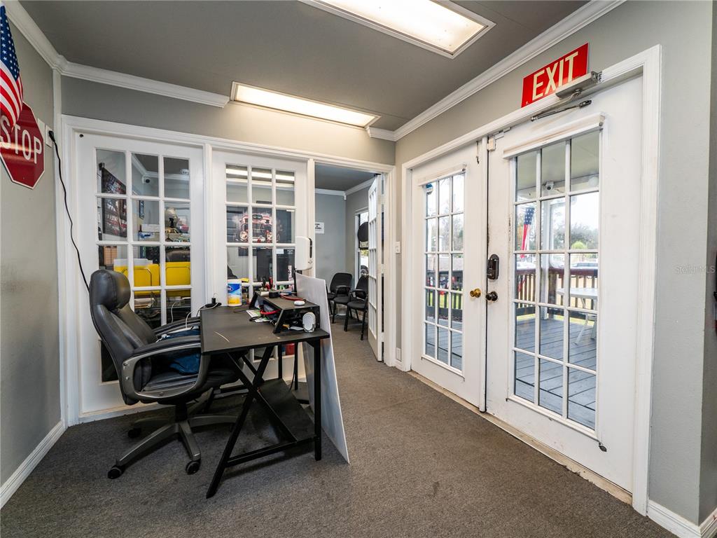 An office space features a desk, a rolling chair, French doors, and an exit sign — 3001 S PINE AVENUE, OCALA, FL