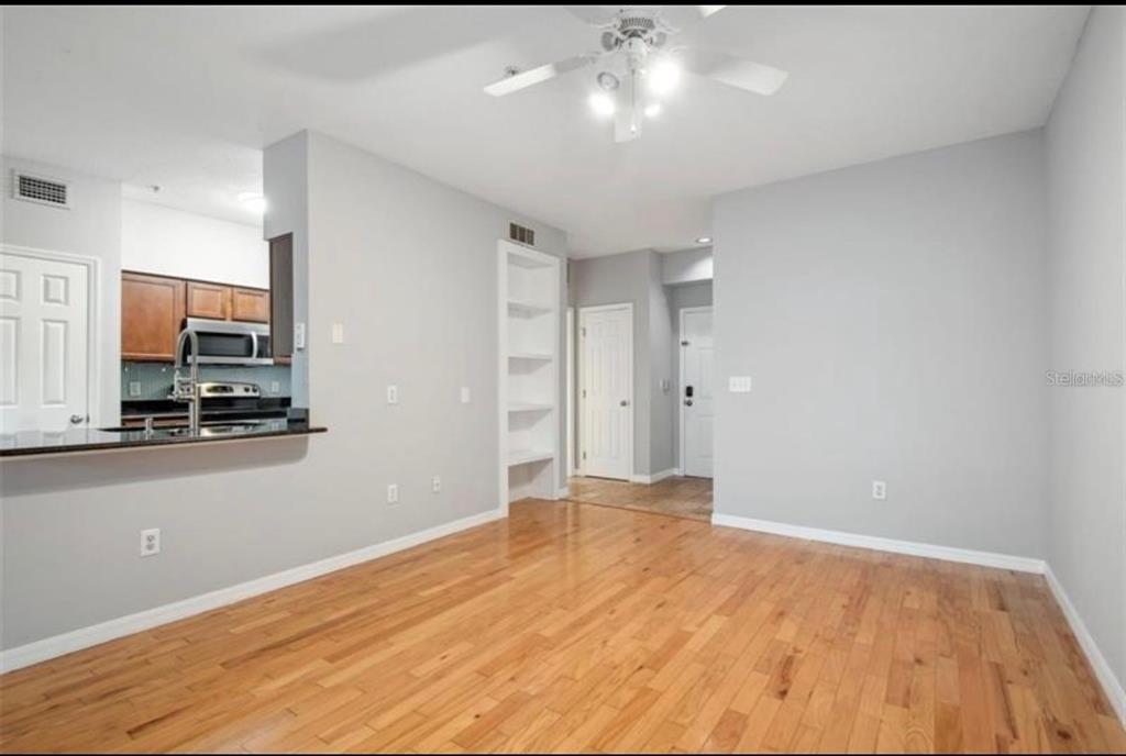 An empty room with light gray walls, hardwood floors, and a white ceiling fan — 1810 E PALM AVENUE UNIT 1205, TAMPA, FL