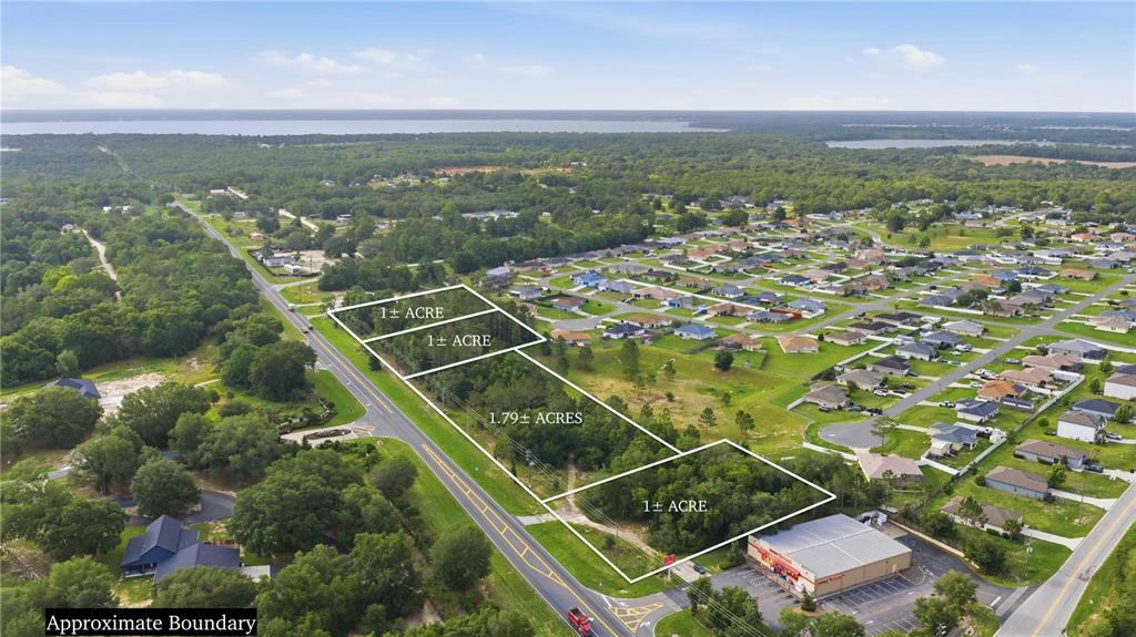 This aerial view shows four adjacent parcels of land outlined in white near a road — TBD CR-25, BELLEVIEW, FL