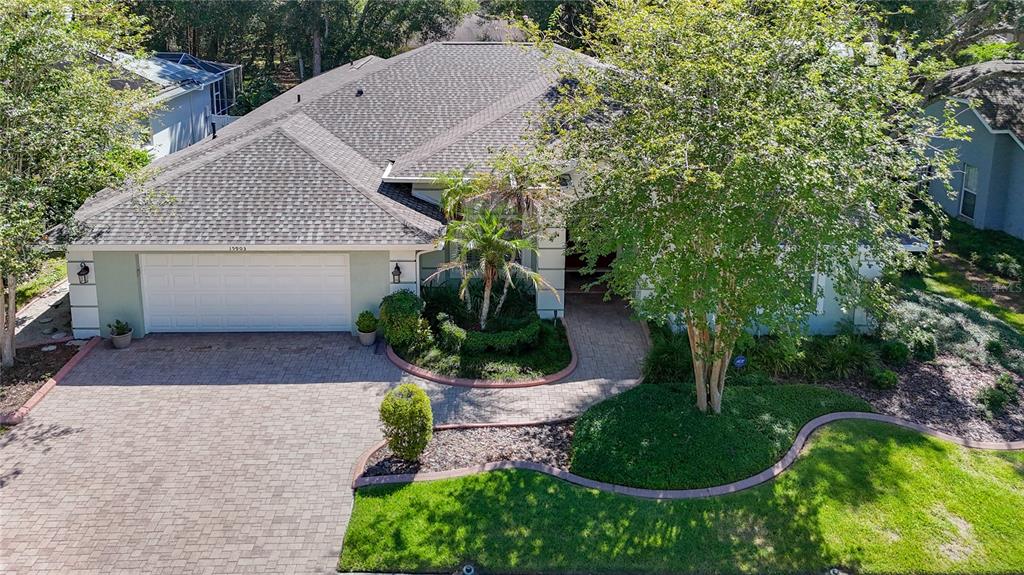 An aerial view of a single-story house with a paved driveway, garage, and landscaped yard — 15903 BROCKWAY PLACE, TAMPA, FL