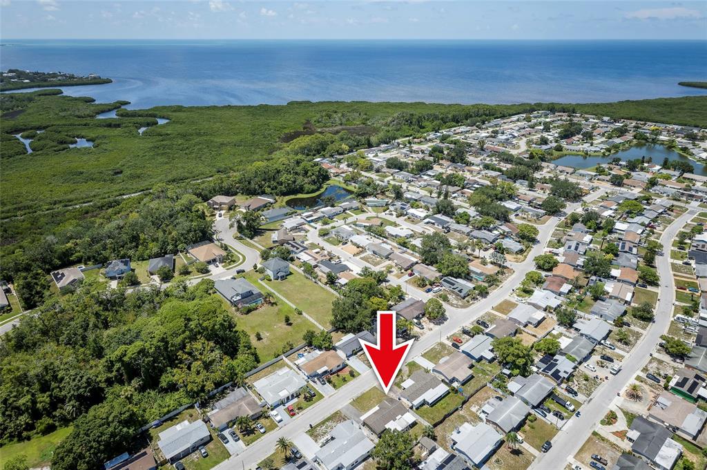 An aerial view shows a residential neighborhood with a red arrow pointing to a house — 3246 BROOKFIELD DRIVE, HOLIDAY, FL