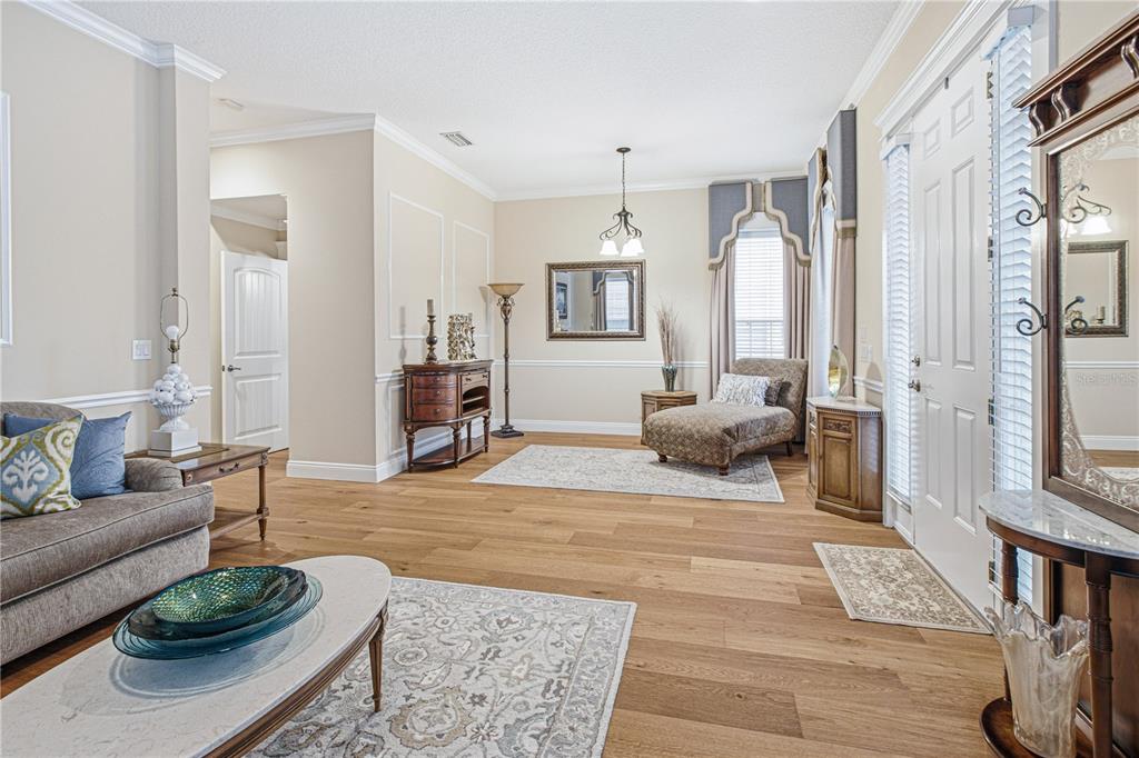 A living room features hardwood floors, a chaise lounge, area rugs, and a front door — 305 STERNWHEEL DRIVE, ST JOHNS, FL