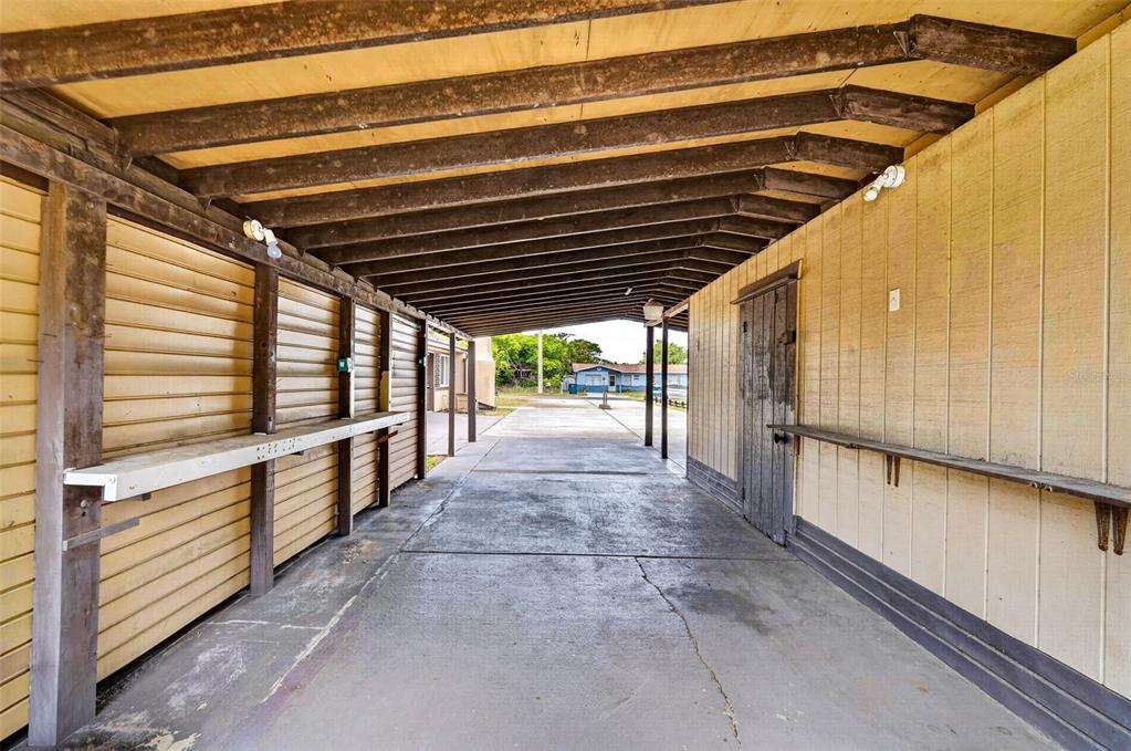A covered outdoor carport with yellow wood siding, a concrete floor, and exposed ceiling beams — 1961 CAROLINA AVENUE, ORMOND BEACH, FL
