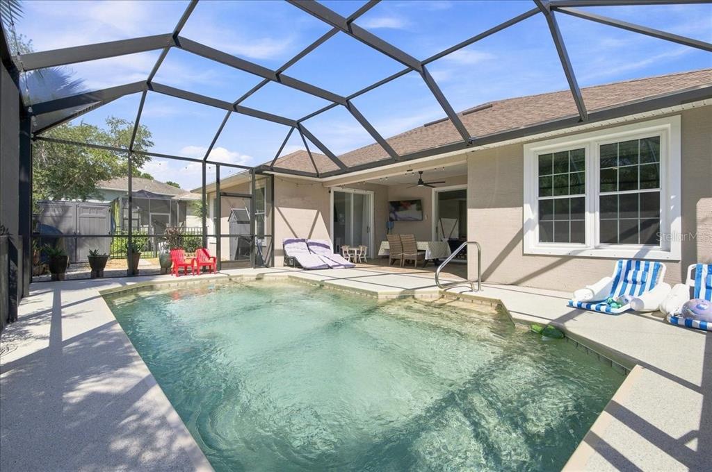 A screened-in patio features a swimming pool, lounge chairs, and a covered dining area — 101 MCGILL CIRCLE, DAYTONA BEACH, FL