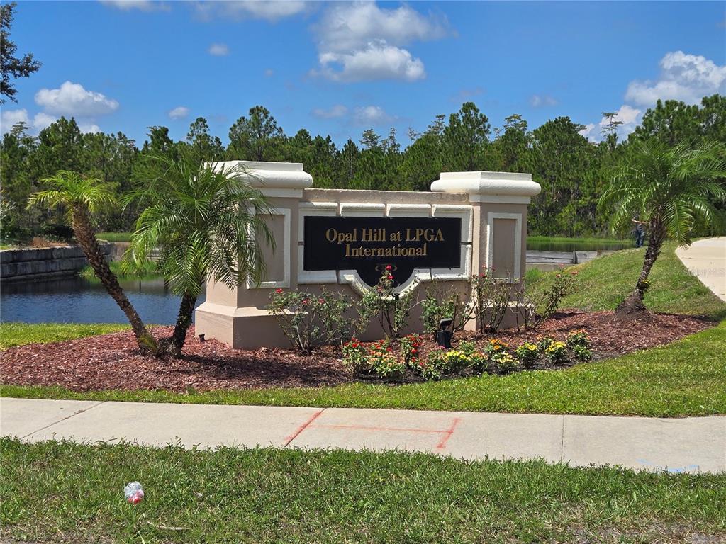 A stone monument sign for Opal Hill at LPGA International sits near a pond — 101 MCGILL CIRCLE, DAYTONA BEACH, FL