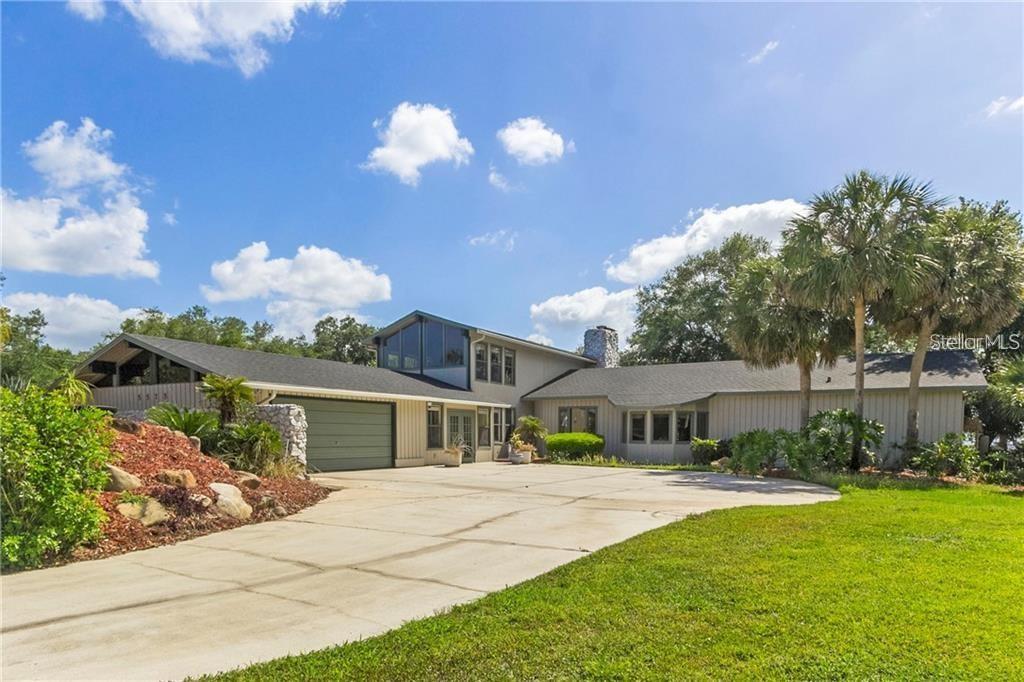 A two-story house with a concrete driveway, stone accents, and a large attached garage — 5575 ALLIGATOR LAKE ROAD, ST CLOUD, FL
