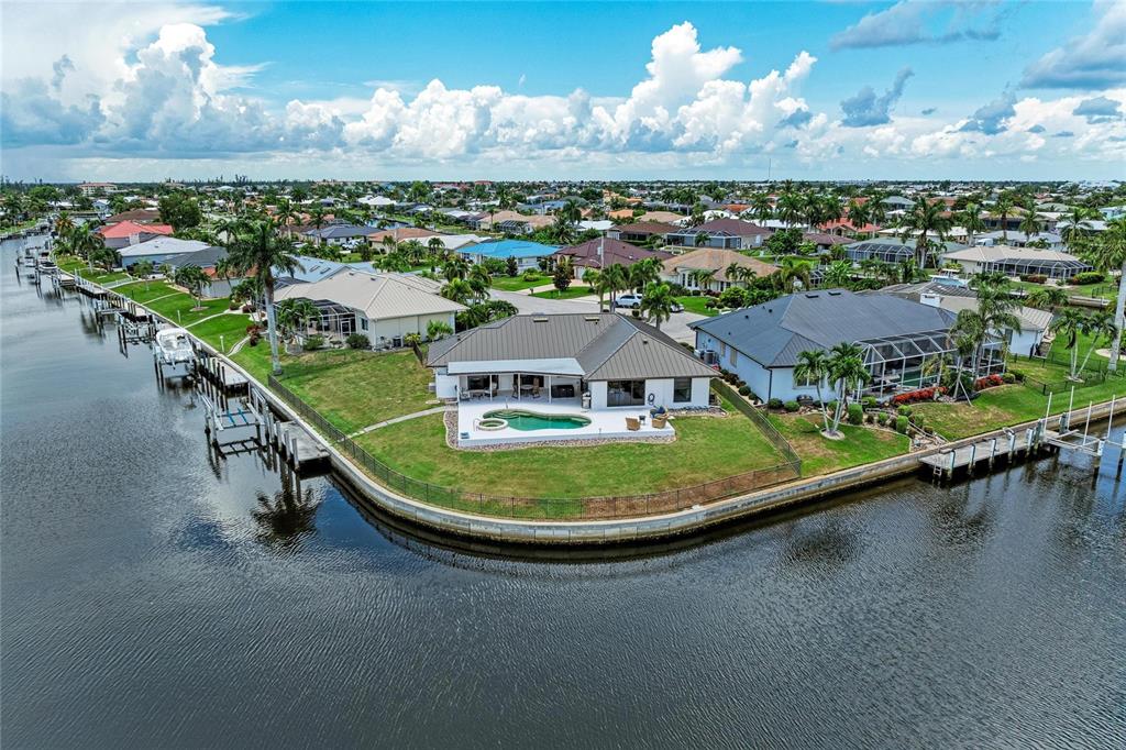 An aerial view shows a waterfront house with a pool and dock on a canal — 602 VIA TUNIS, PUNTA GORDA, FL