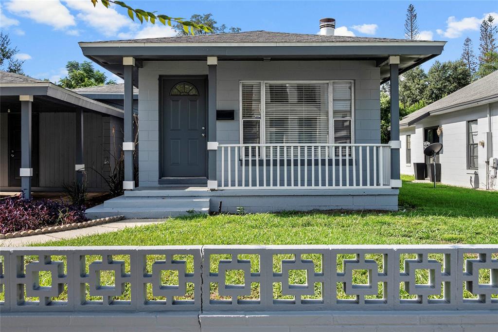 A gray single-story house with a front porch and a decorative concrete block wall — 450 W CANTON AVENUE, WINTER PARK, FL