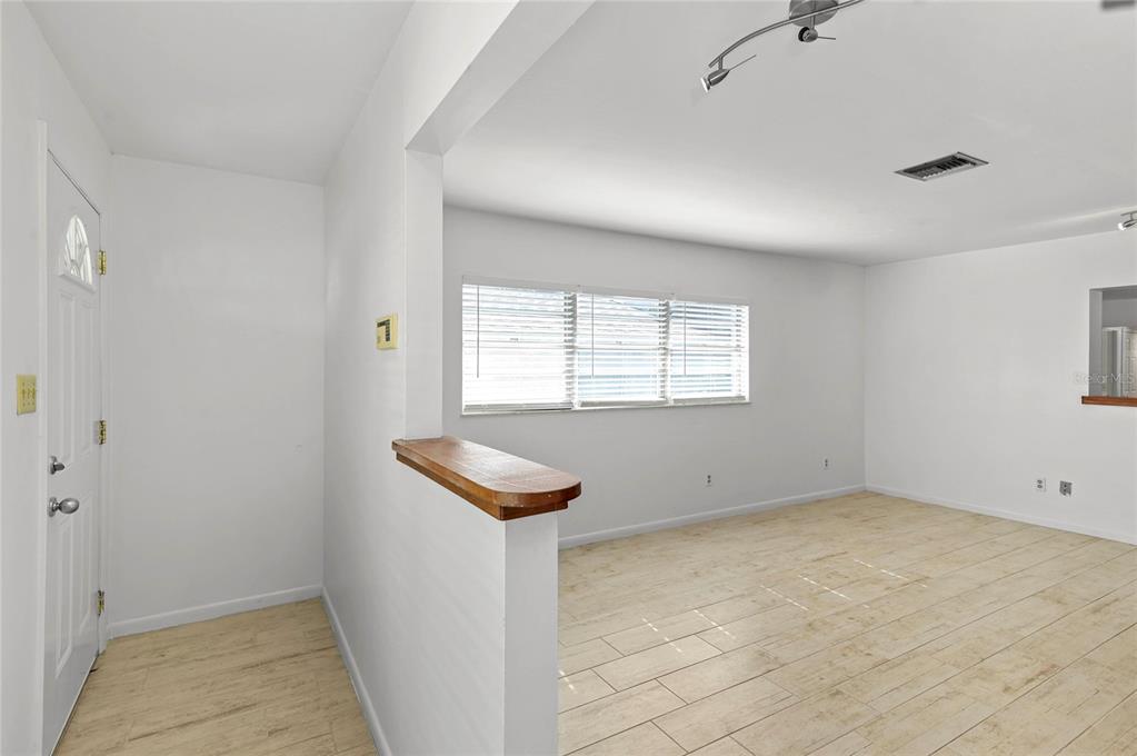 An interior view of a living room with white walls, tile flooring, and a half-wall — 450 W CANTON AVENUE, WINTER PARK, FL