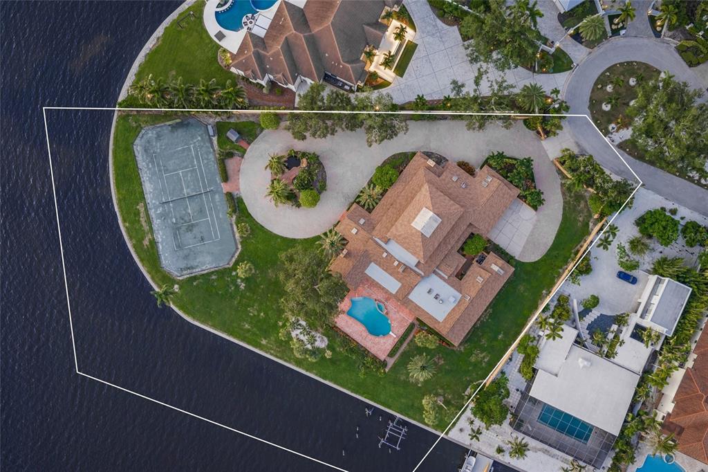 Aerial view of a waterfront property featuring a tennis court, swimming pool, and circular driveway — 1136 N LAKE SHORE DRIVE, SARASOTA, FL