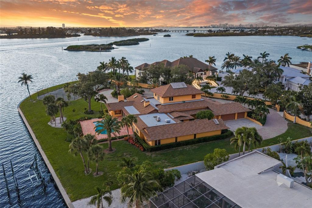 An aerial view of a waterfront estate featuring a large house, pool, and private dock — 1136 N LAKE SHORE DRIVE, SARASOTA, FL