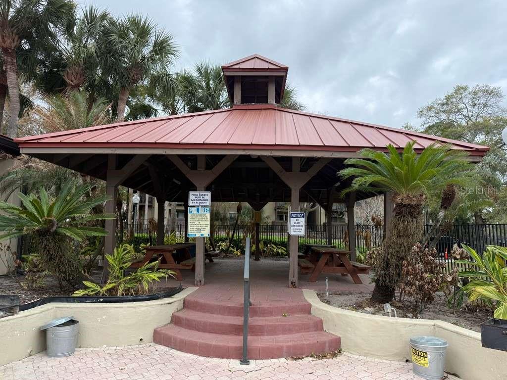 A covered outdoor pavilion with a metal roof features picnic tables and a small staircase — 216 AFTON SQUARE UNIT 304, ALTAMONTE SPRINGS, FL